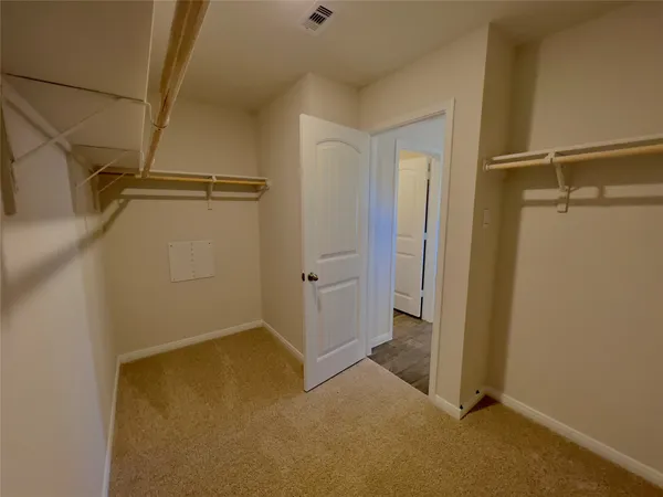 a view of an empty room with closet and a window