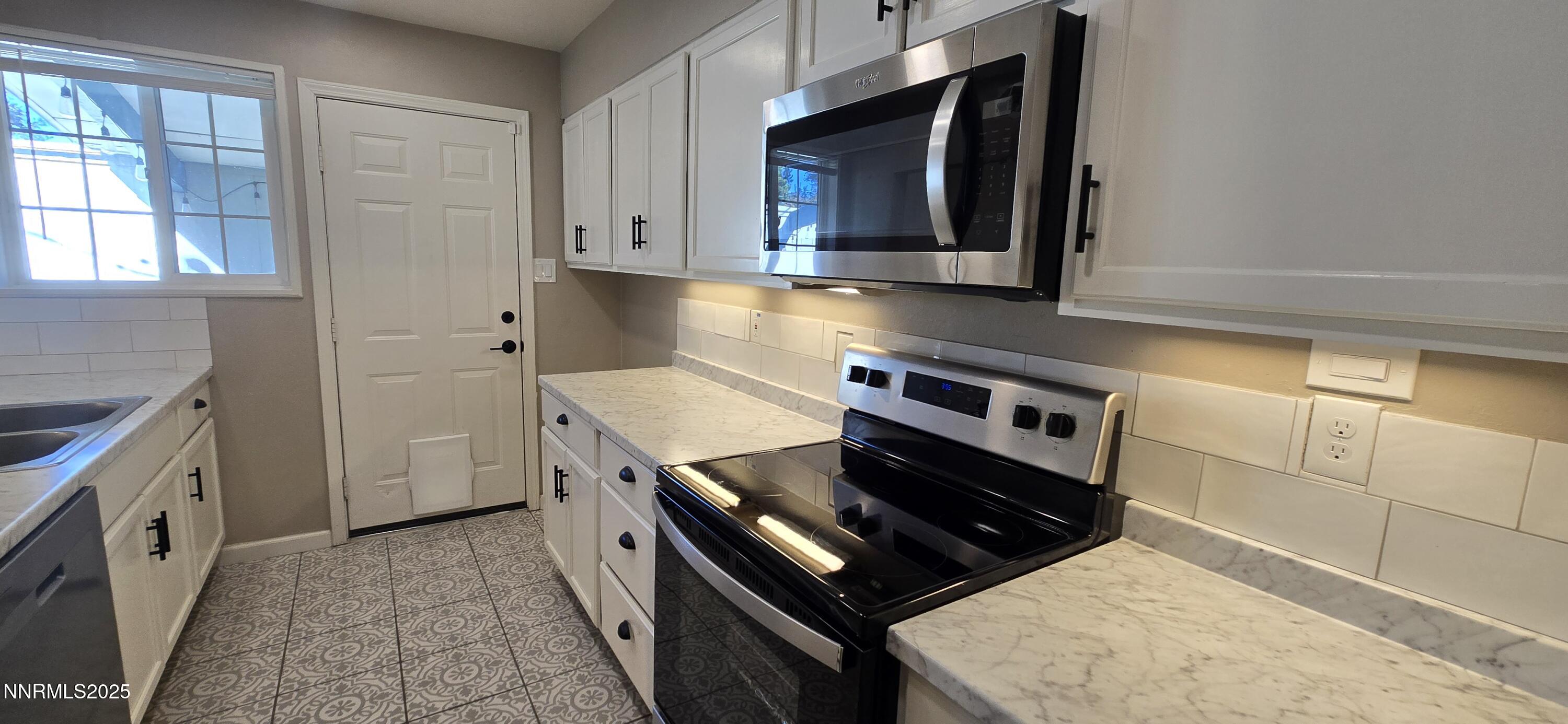 13562 Mt Baldy Street Reno, NV 89506 - Photo 2 of 9 a kitchen with stainless steel appliances granite countertop a stove a sink and a microwave