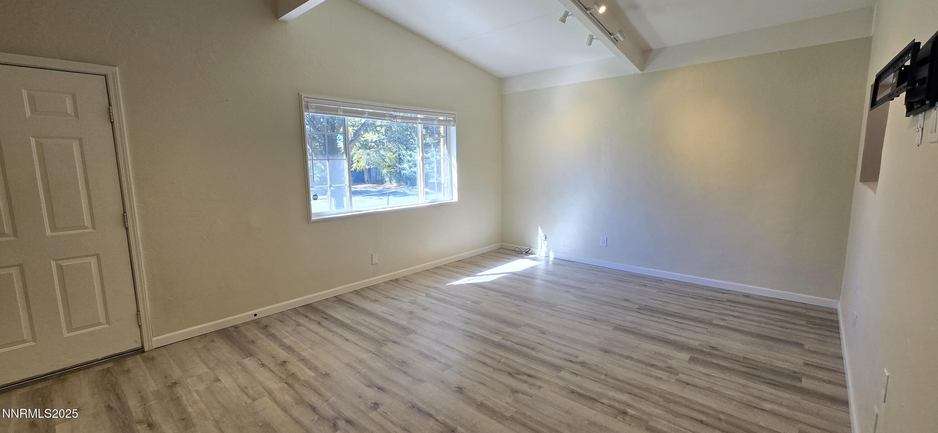 13562 Mt Baldy Street Reno, NV 89506 - Photo 4 of 9 an empty room with wooden floor and windows