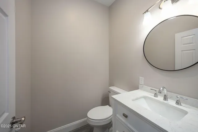a bathroom with a toilet a sink and mirror
