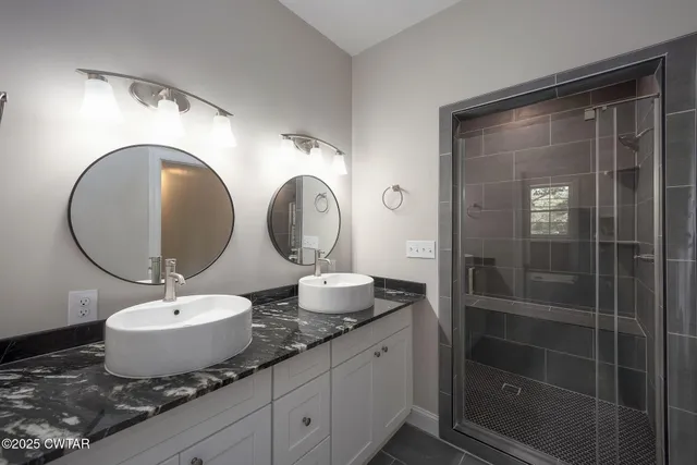 a bathroom with a granite countertop sink mirror and shower