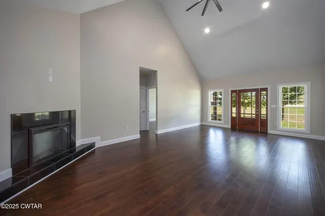 a view of an empty room with window and wooden floor