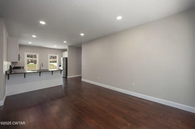 a view of a kitchen with a refrigerator and a view of living room