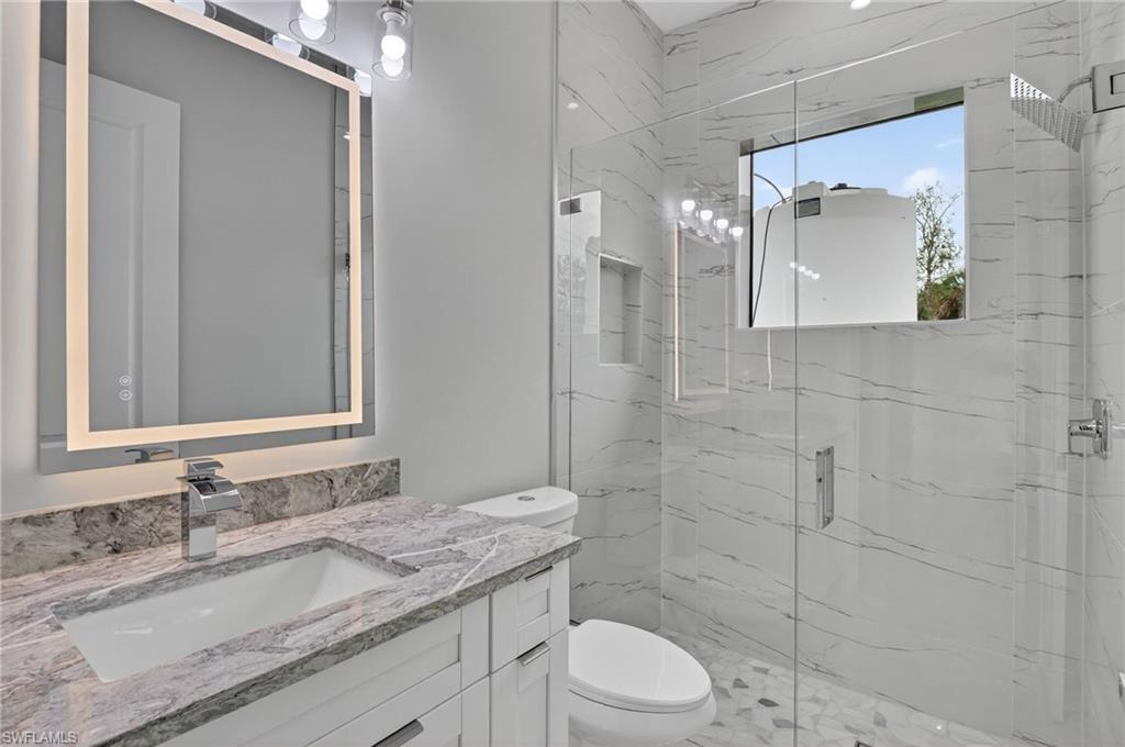 563 15th Street Northwest Naples, FL 34120 - Photo 15 of 33 Bathroom with vanity and a marble finish shower