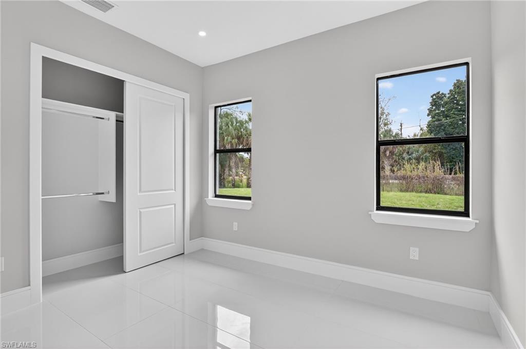 563 15th Street Northwest Naples, FL 34120 - Photo 20 of 33 Unfurnished bedroom featuring tile patterned flooring, a closet, and recessed lighting