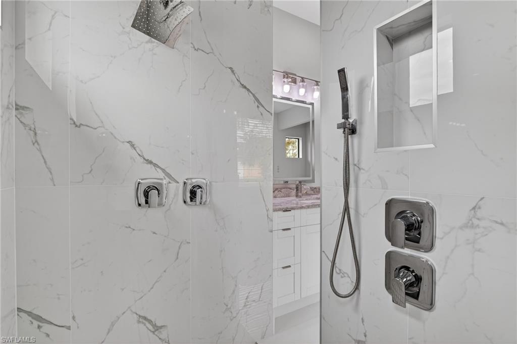 563 15th Street Northwest Naples, FL 34120 - Photo 21 of 33 Bathroom with vanity and a marble finish shower