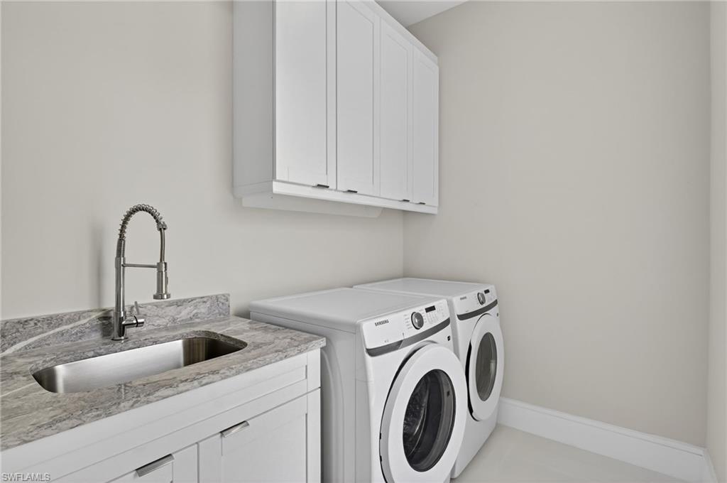 563 15th Street Northwest Naples, FL 34120 - Photo 24 of 33 Washroom featuring washing machine and clothes dryer and cabinet space