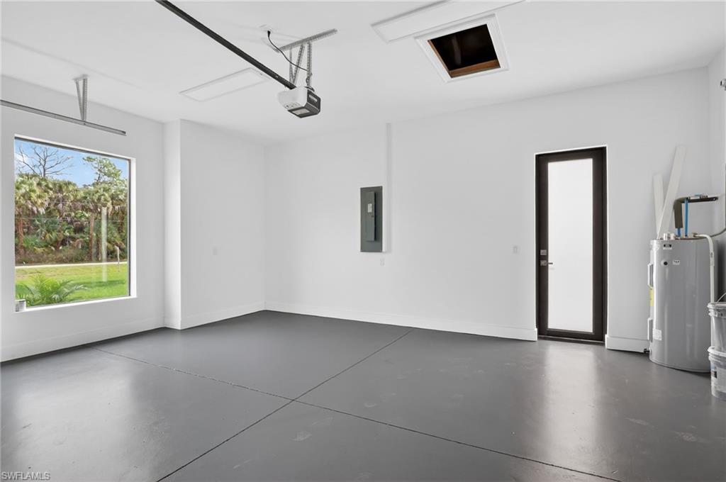 563 15th Street Northwest Naples, FL 34120 - Photo 25 of 33 Garage with electric panel, water heater, and a garage door opener