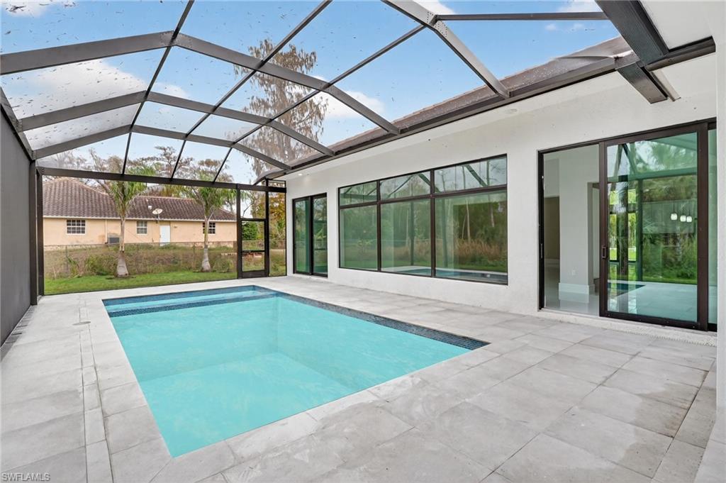 563 15th Street Northwest Naples, FL 34120 - Photo 27 of 33 Outdoor pool with a sunroom, a patio area, and a lanai