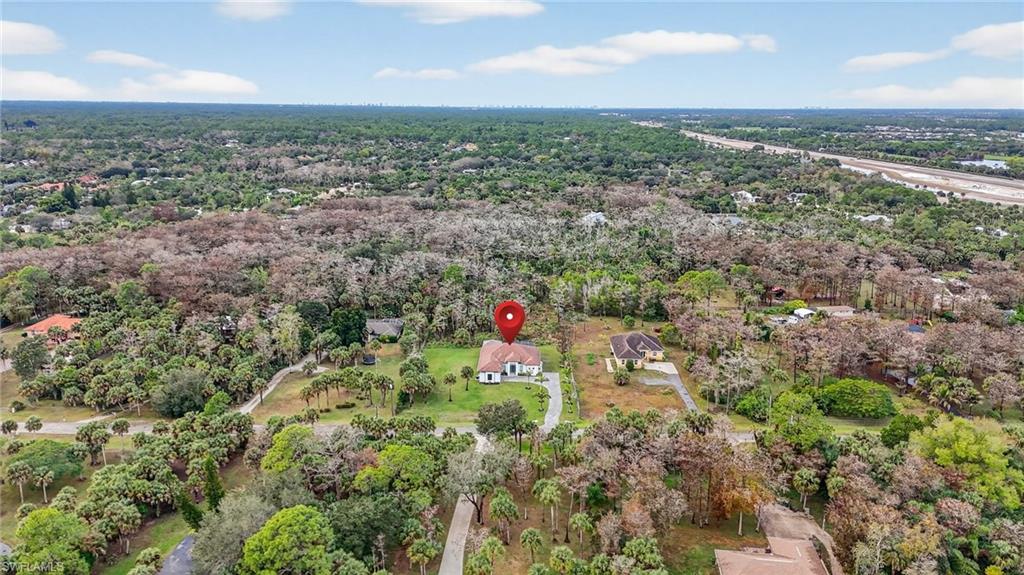 563 15th Street Northwest Naples, FL 34120 - Photo 31 of 33 Aerial view of property and surrounding area featuring a heavily wooded area