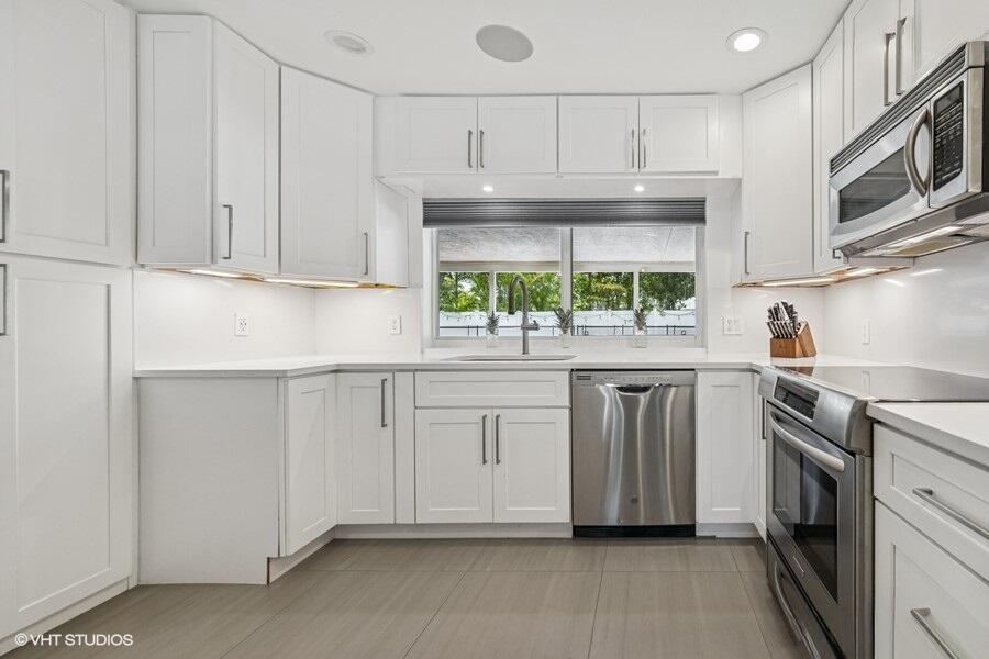 746 Southwest 2nd Street Boca Raton, FL 33486 - Photo 11 of 54 a kitchen with white cabinets and white appliances
