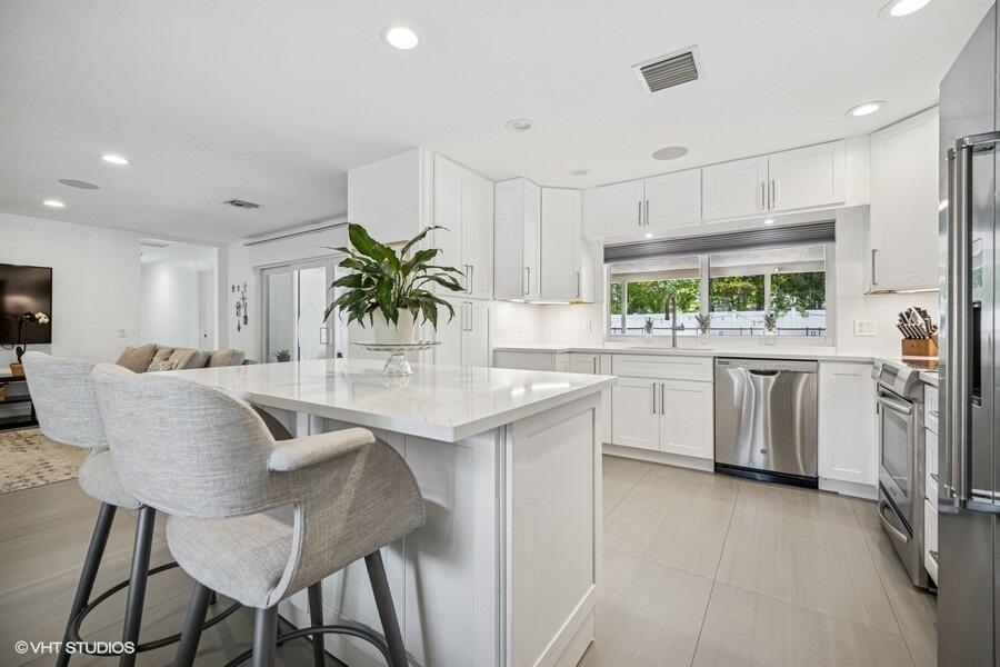 746 Southwest 2nd Street Boca Raton, FL 33486 - Photo 12 of 54 a kitchen with counter top space cabinets and stainless steel appliances