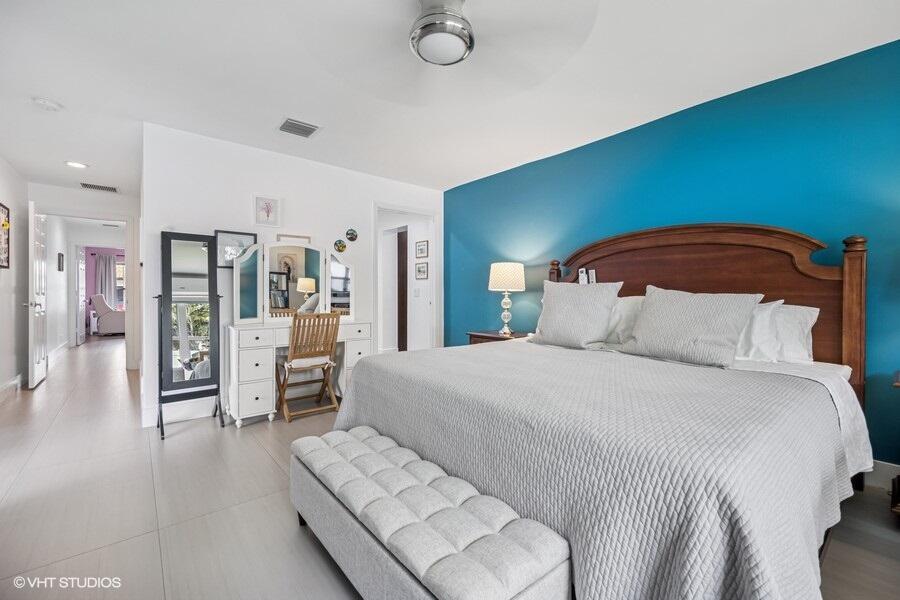 746 Southwest 2nd Street Boca Raton, FL 33486 - Photo 18 of 54 a bedroom with a large bed and a chandelier