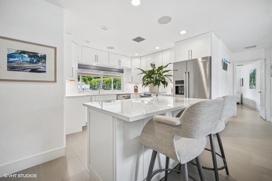 746 Southwest 2nd Street Boca Raton, FL 33486 - Photo 10 of 54 a kitchen with stainless steel appliances granite countertop a table and chairs in it