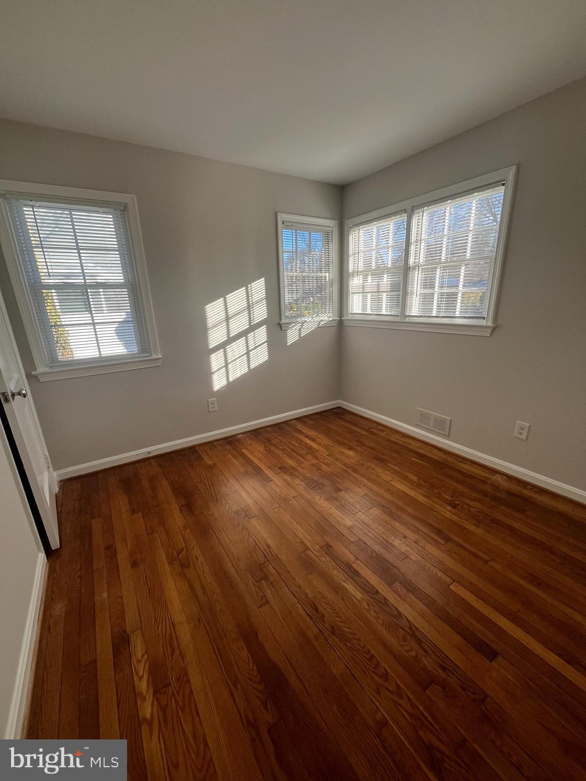7908 Wellington Road Alexandria, VA 22308 - Photo 11 of 16 a view of an empty room with wooden floor and a window
