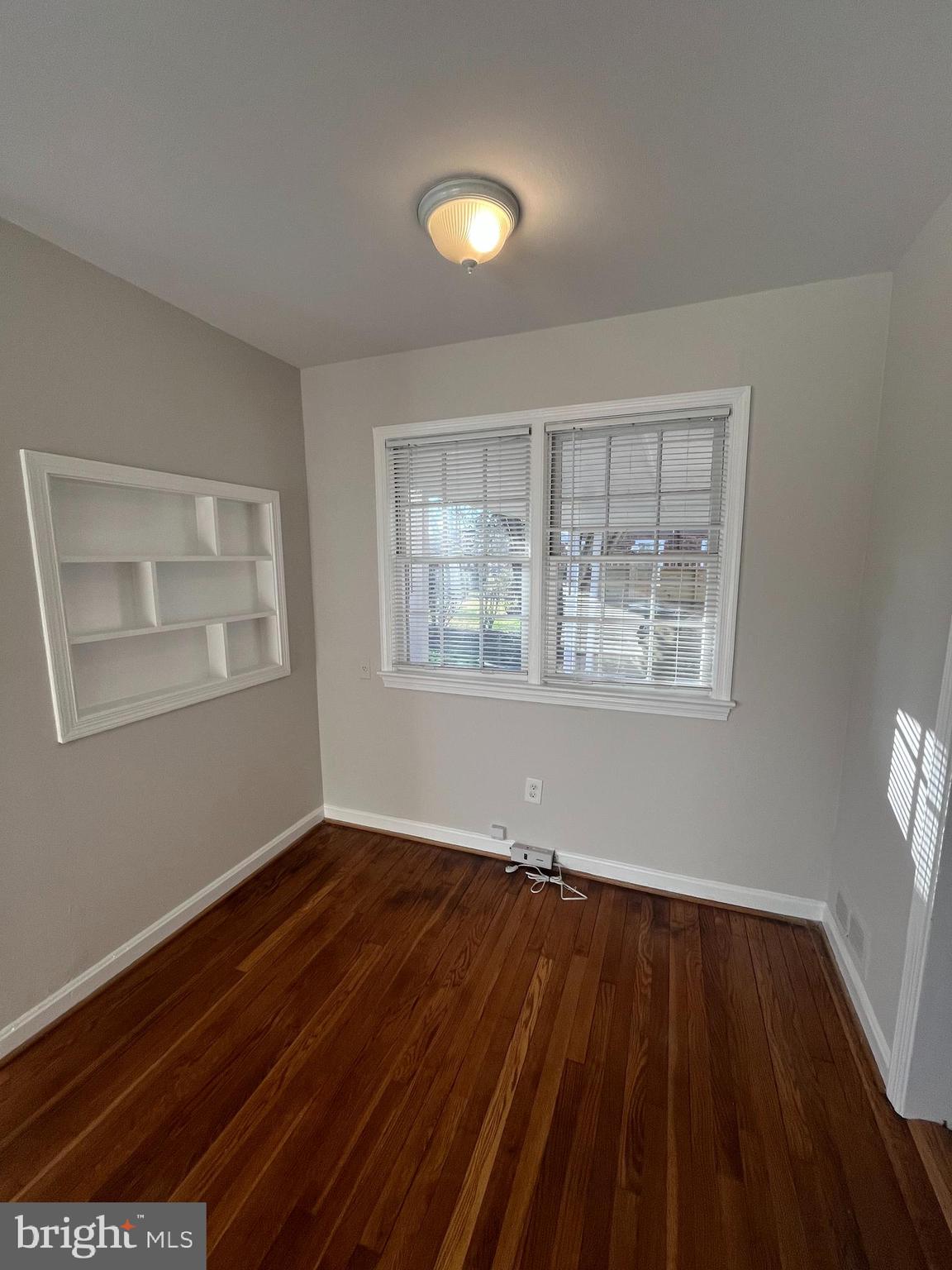 7908 Wellington Road Alexandria, VA 22308 - Photo 6 of 16 a view of an empty room with wooden floor and a window
