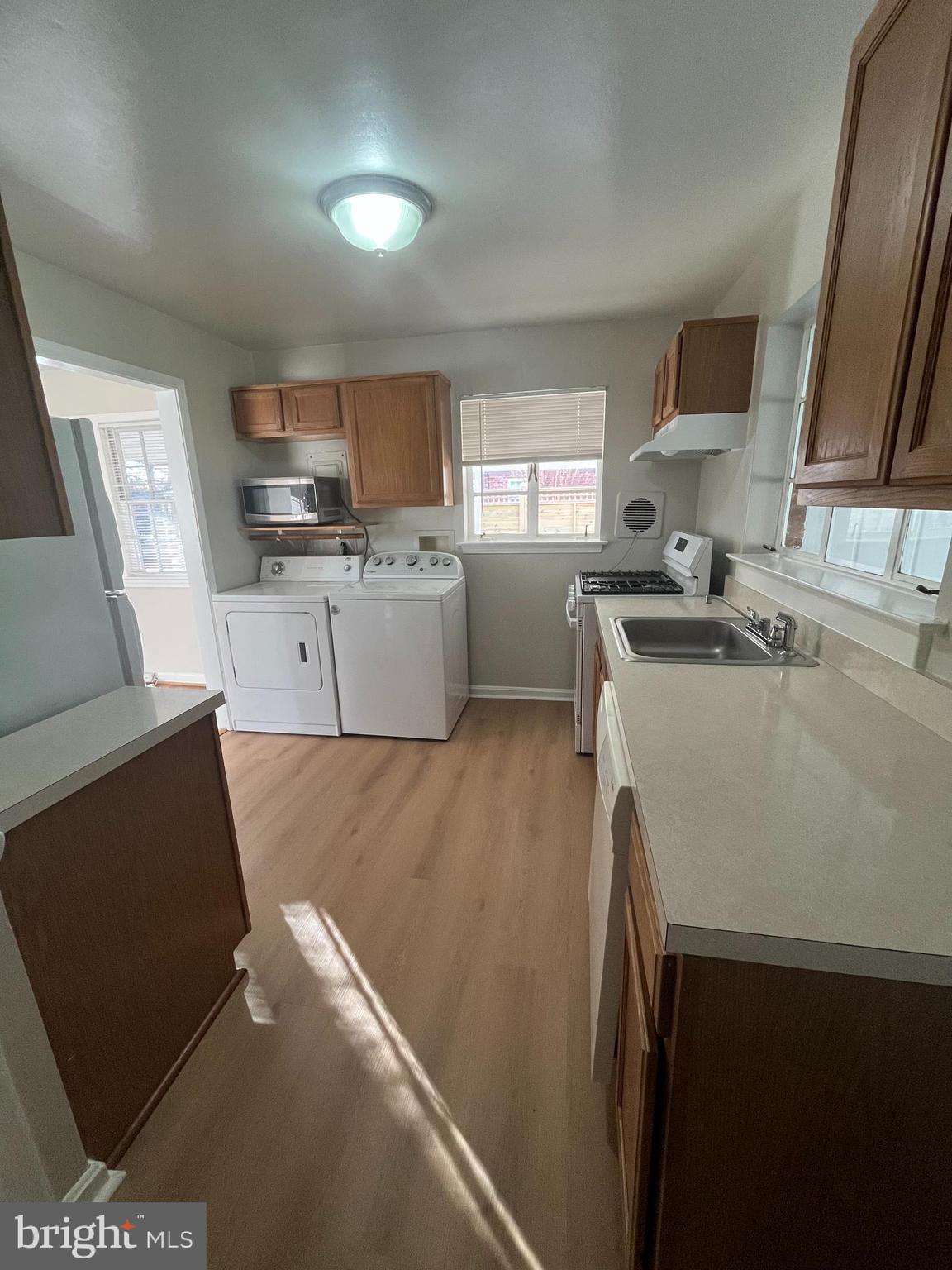 7908 Wellington Road Alexandria, VA 22308 - Photo 8 of 16 a kitchen with a sink a stove cabinets and a wooden floor