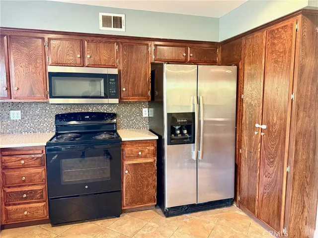 a kitchen with granite countertop wooden cabinets and stainless steel appliances
