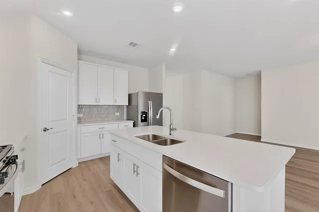 a kitchen that has a sink a stove and a refrigerator