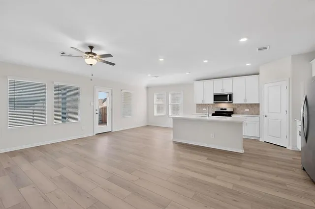 a view of kitchen with refrigerator stove and wooden floor