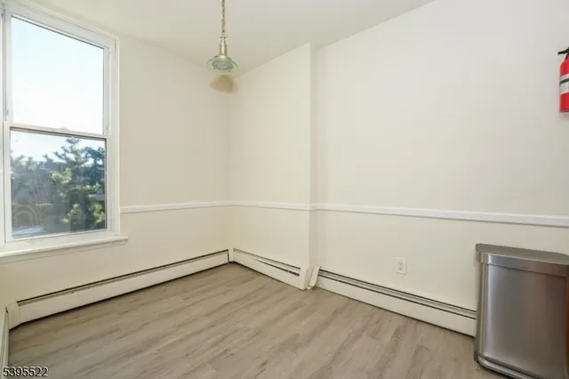 a view of a room with wooden floor and white walls