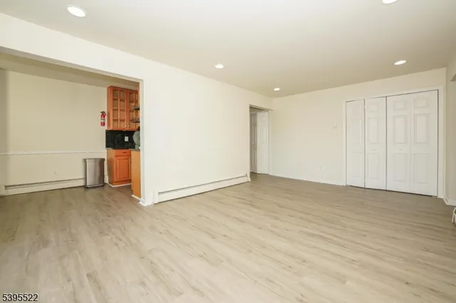 a view of empty room with wooden floor