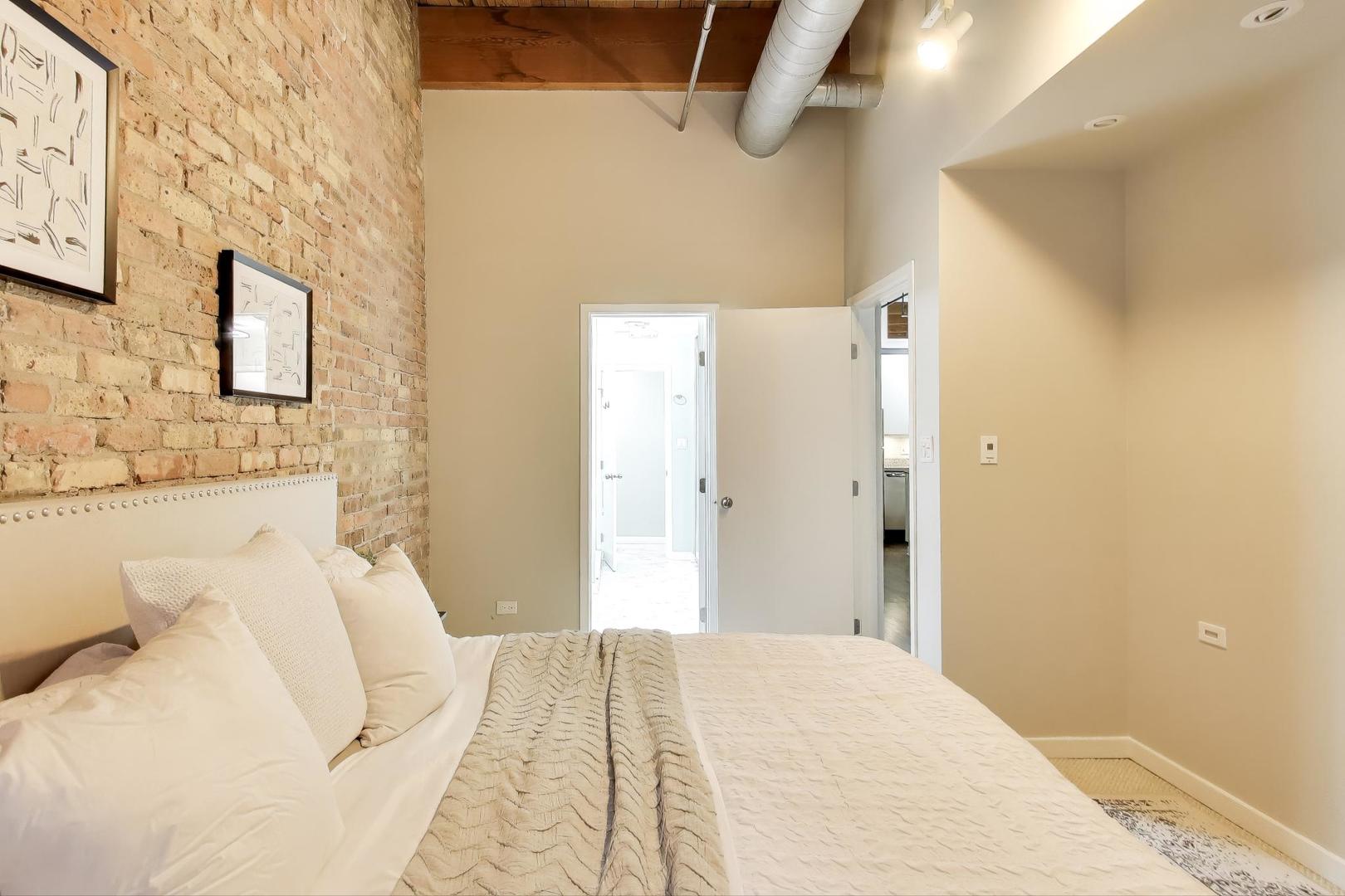 300 West Grand Avenue, Unit 210 Chicago, IL 60654 - Photo 11 of 20 a bedroom with a bed and a mirror