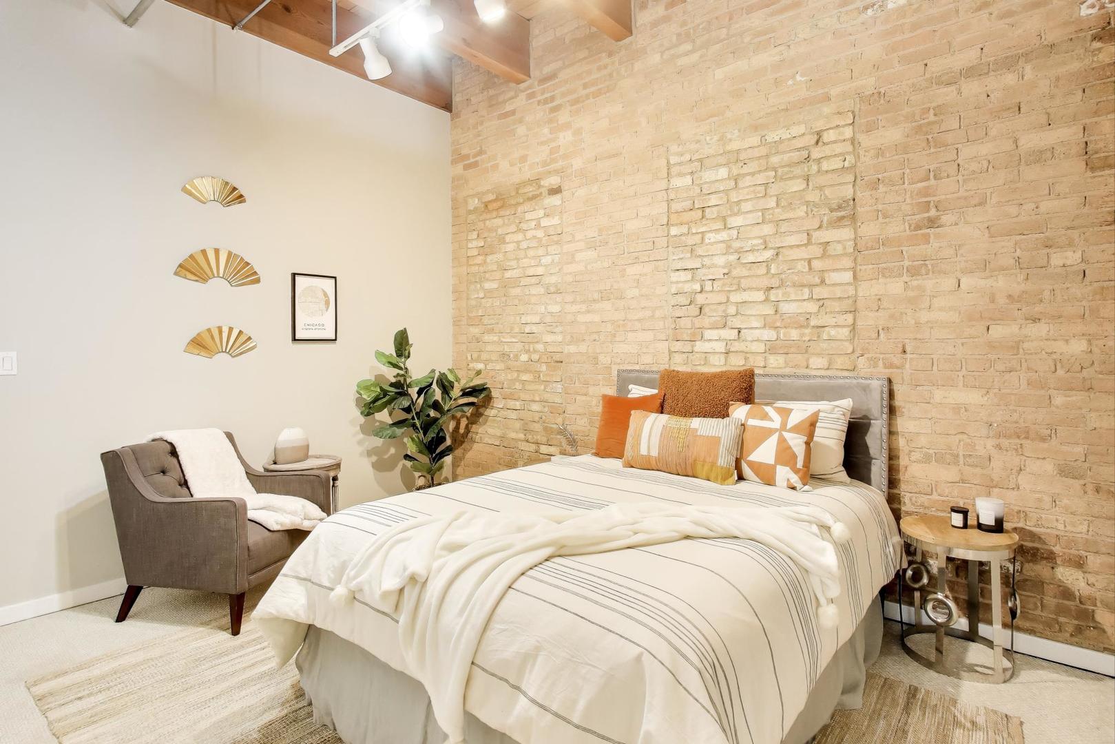 300 West Grand Avenue, Unit 210 Chicago, IL 60654 - Photo 12 of 20 a bedroom with a bed and a chair