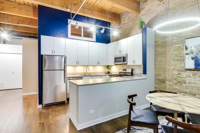 a kitchen with stainless steel appliances granite countertop a refrigerator a stove top oven a sink and dishwasher