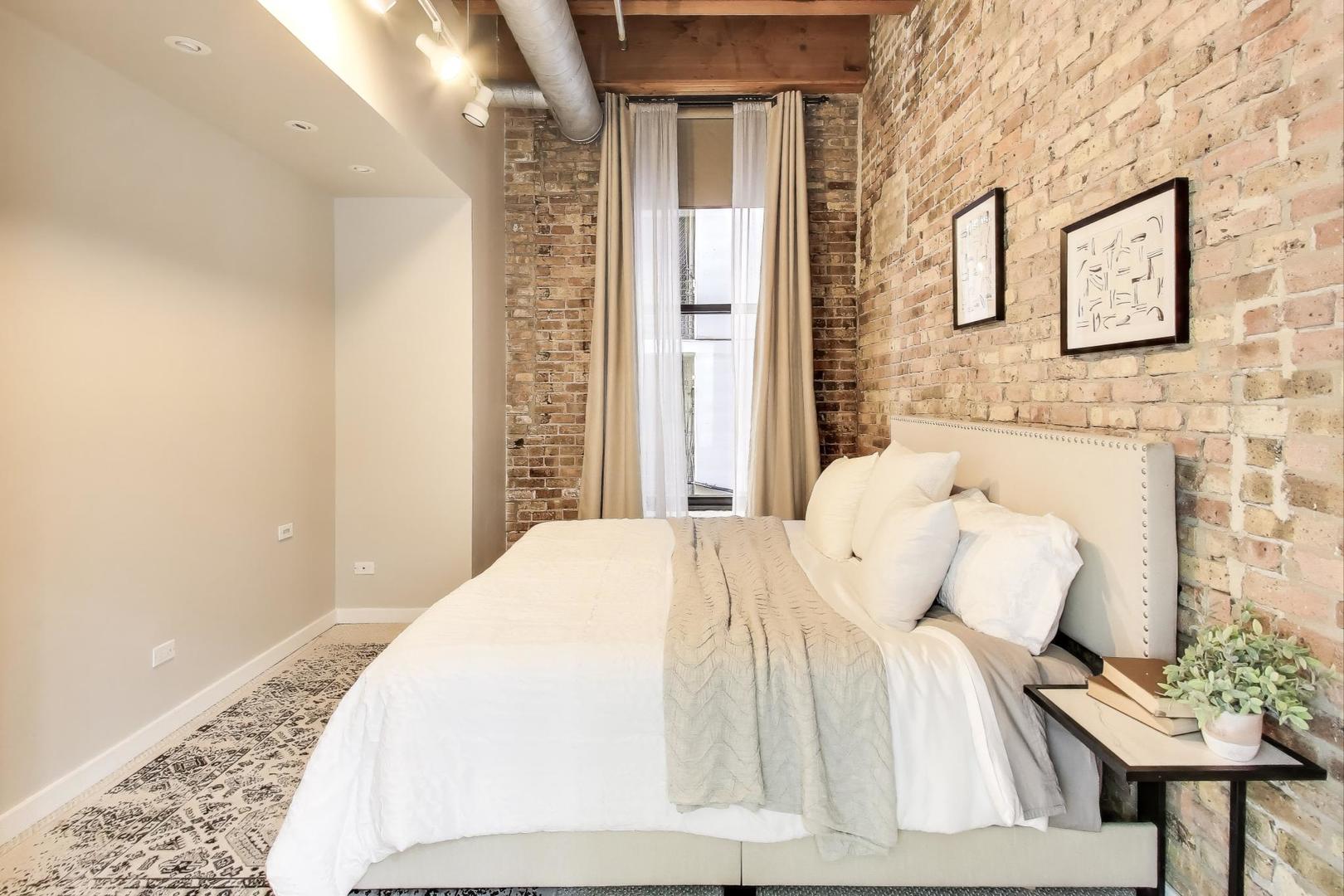 300 West Grand Avenue, Unit 210 Chicago, IL 60654 - Photo 7 of 20 a bedroom with a bed and a couch