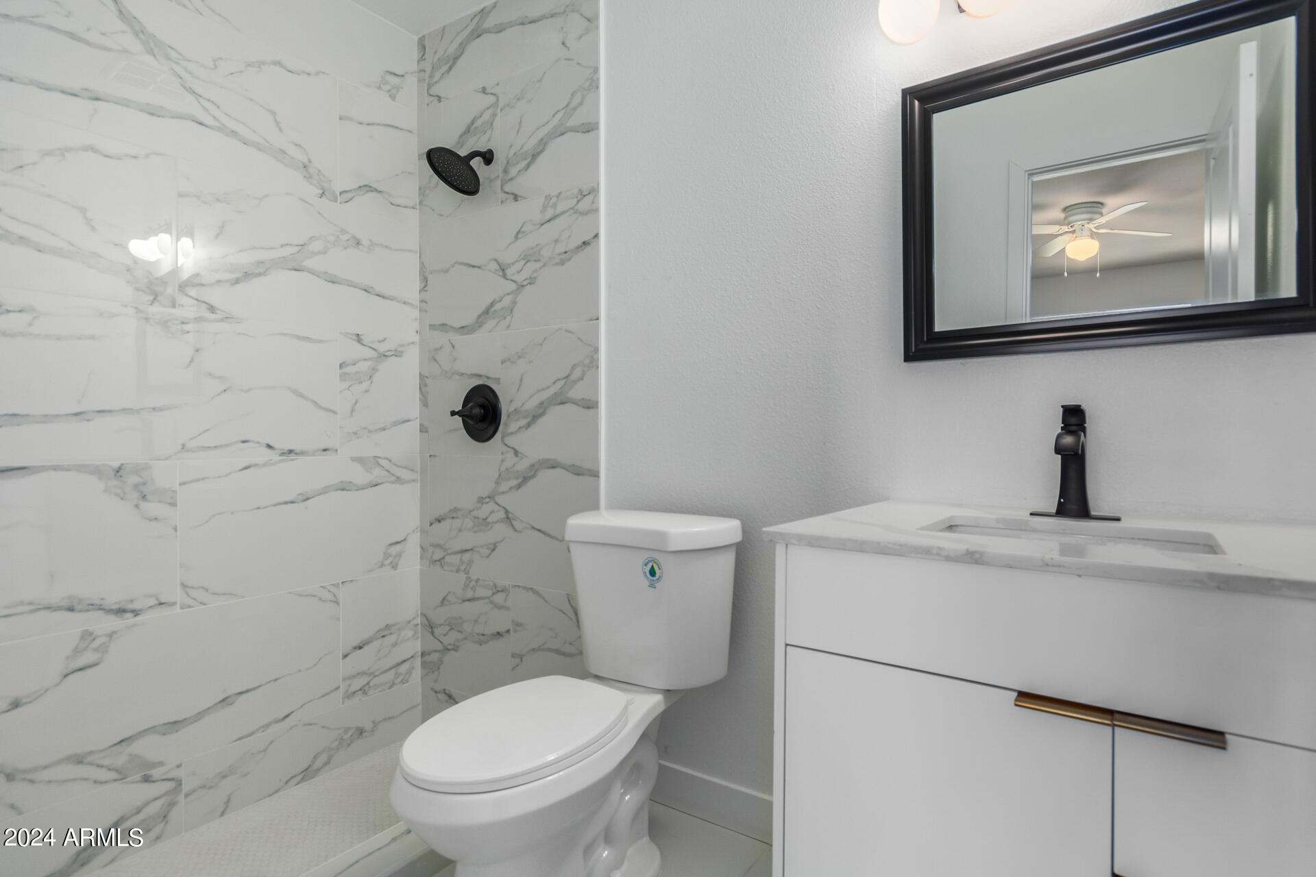 5338 West Coronado Road Phoenix, AZ 85035 - Photo 14 of 29 a bathroom with a toilet sink and mirror