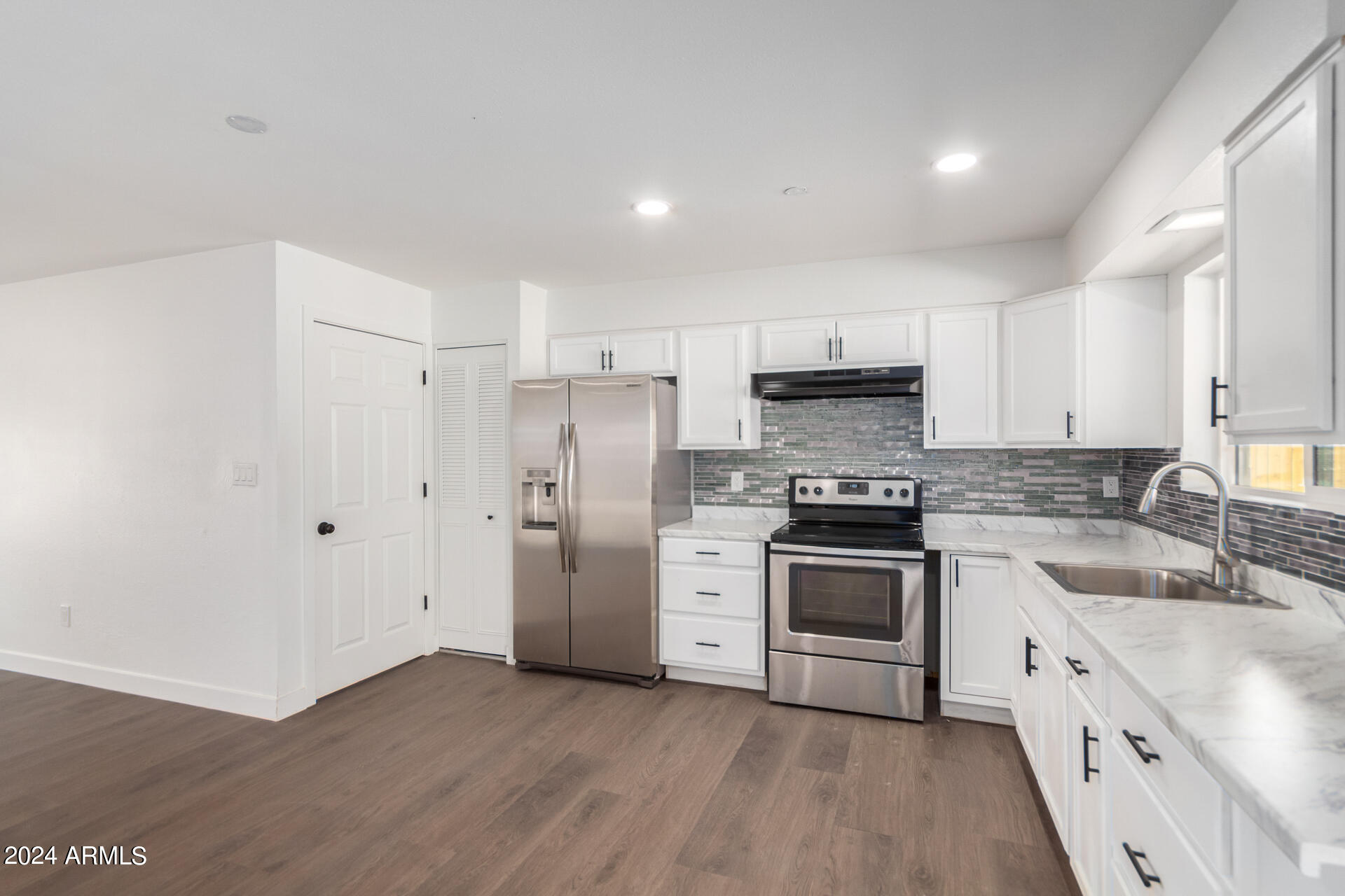 5338 West Coronado Road Phoenix, AZ 85035 - Photo 9 of 29 a kitchen with granite countertop white cabinets and stainless steel appliances