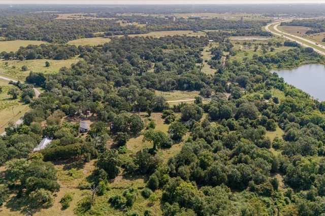 an aerial view of residential houses with outdoor space and trees