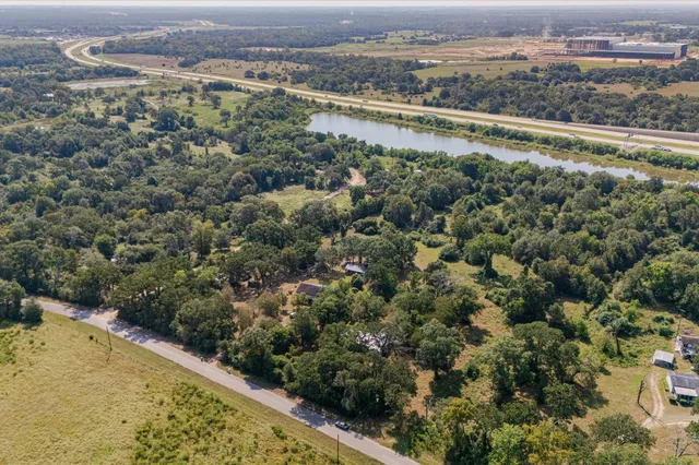 an aerial view of a house with a yard and lake view