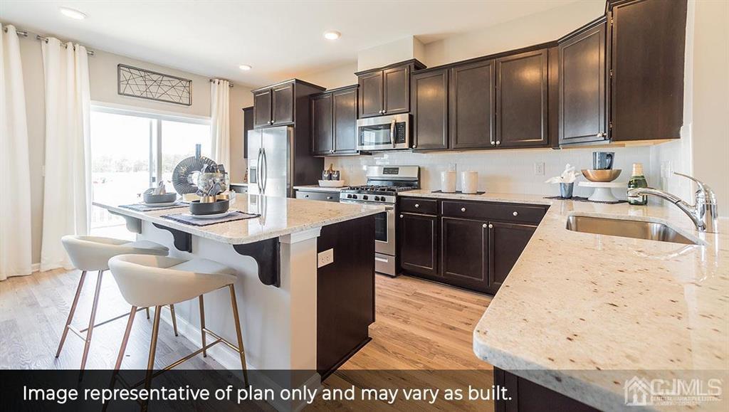 105 Matutina Road Iselin, NJ 08830 - Photo 5 of 20 a large kitchen with kitchen island granite countertop wooden cabinets a stove a sink and dishwasher