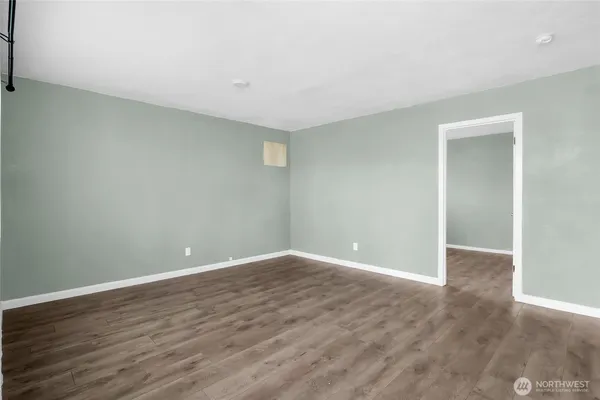 a view of an empty room with wooden floor