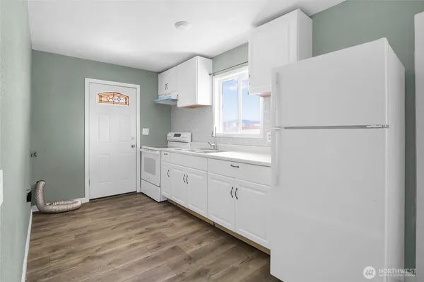 a kitchen with a refrigerator sink stove and white cabinets