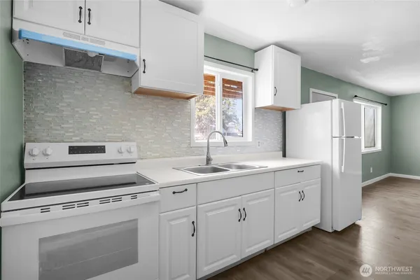 a kitchen with stainless steel appliances white cabinets and a sink