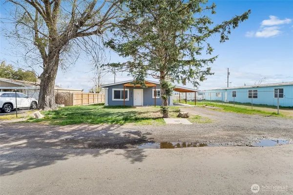 a view of a house with a big yard and large trees