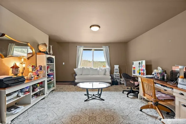 a living room with furniture a desk and a book shelf