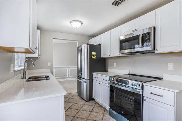 a kitchen with stainless steel appliances a stove microwave and sink