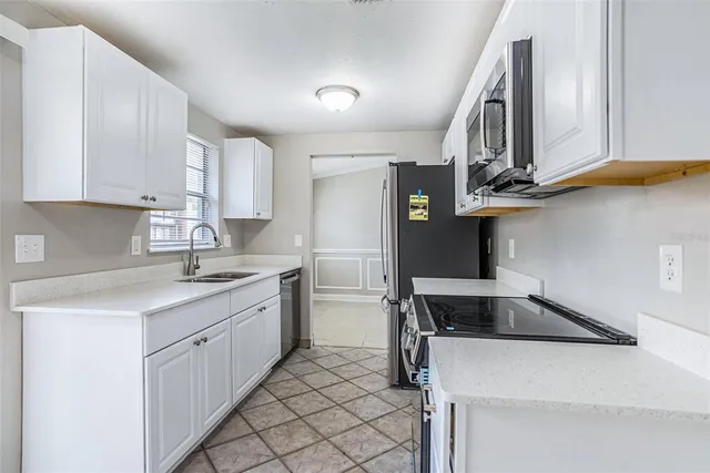 a kitchen with a sink cabinets and appliances