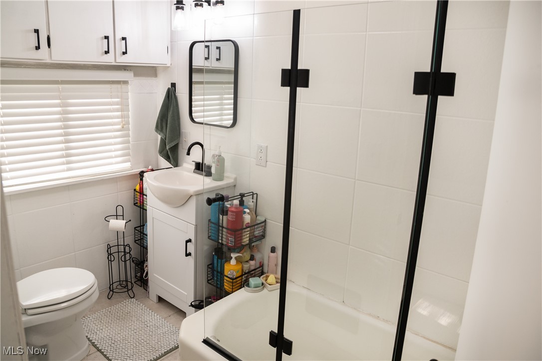 95 Clingan Road Struthers, OH 44471 - Photo 39 of 46 Full bath featuring vanity, a tub with shower, and tile walls