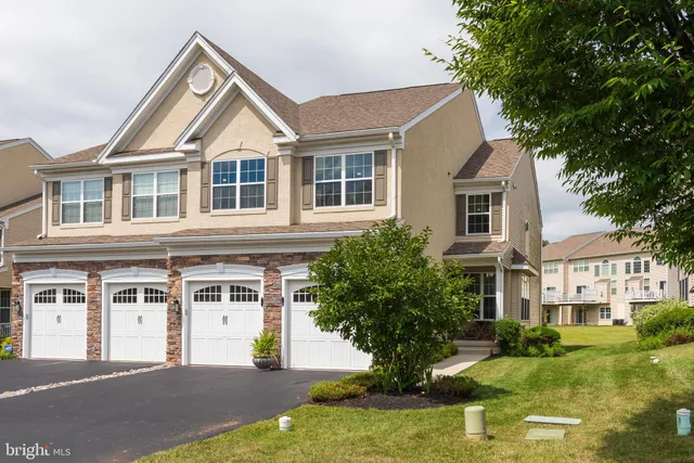 a front view of a house with a yard garage and trees