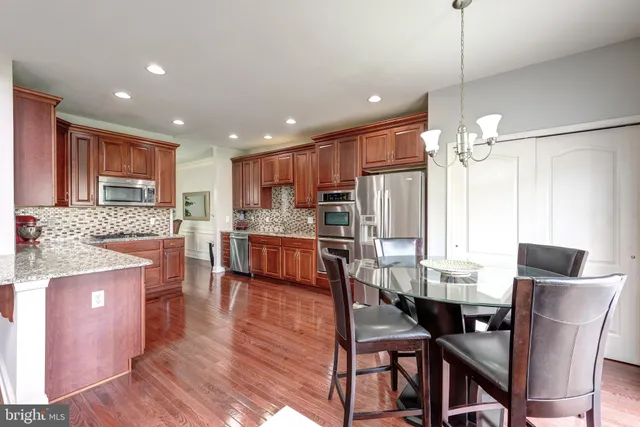 a kitchen with kitchen island granite countertop wooden floors and stainless steel appliances