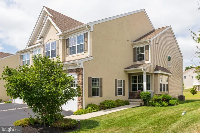 a front view of a house with a yard and trees