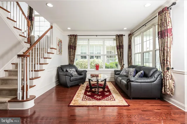 a living room with furniture floor to ceiling windows and a dining table