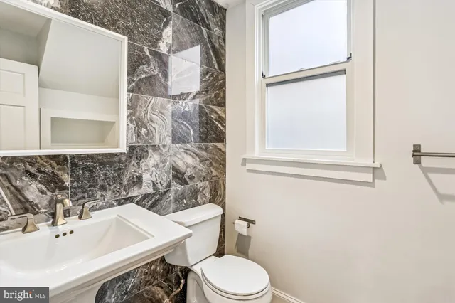 a bathroom with a sink toilet and mirror
