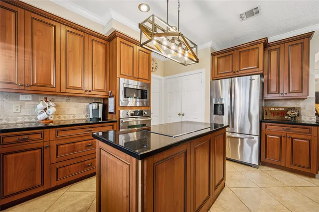 a kitchen with stainless steel appliances granite countertop a refrigerator and wooden cabinets