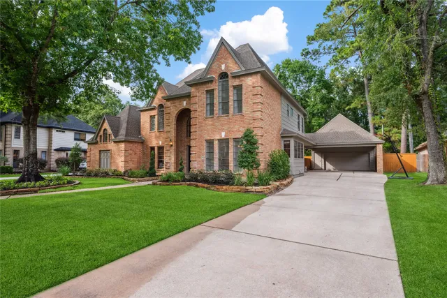 a front view of a house with a yard and trees